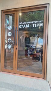 Sticker Cutting tulisan jam operasional di pintu kaca