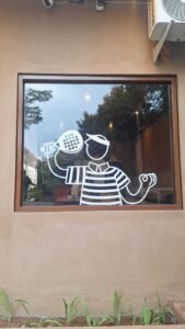 Sticker Cutting ilustrasi karakter dengan raket padel pada jendela di Bali