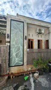 Sticker Cutting sandblast dengan desain pola daun minimalis pada kaca jendela rumah di kawasan Bali.