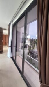 Kaca film transparan pada pintu geser kaca lantai dua rumah di Bali
