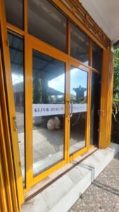 Pemasangan kaca film gelap pada pintu dan jendela kantor di Bali, tampak eksterior gedung Klinik Hukum Sudidjaja Institute dengan bingkai kuning.