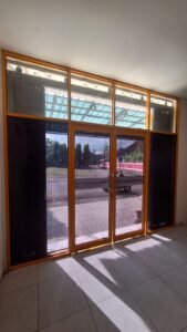 Tampak interior hasil pemasangan kaca film gelap pada jendela dan pintu kaca kantor di Bali, sisi samping berfilm hitam pekat untuk privasi, pintu tengah transparan, gedung Klinik Hukum Sudidjaja Institute