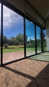 Kaca film biru reflektif pada pintu geser kaca gedung di Bali