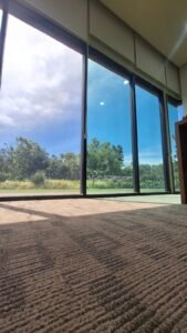 Kaca film biru reflektif pada jendela kaca besar gedung di Bali