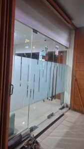 Sticker Sandblast motif garis vertikal abstrak pada kaca pintu geser toko di Bali