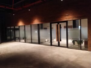 Sticker Sandblast motif garis horizontal pada kaca partisi dan pintu masuk lobby gedung industrial di Bali