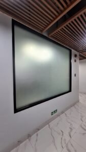 Sticker Sandblast polos full frosted pada kaca jendela bingkai hitam di koridor gedung bertingkat di Bali