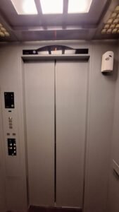 Sticker Solid warna abu-abu muda pada dinding sisi pintu interior lift di Bali