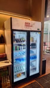 Sticker Print branding Nusa Padel Club pada bagian atas kulkas display minuman di Bali