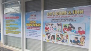 Sticker Print banner promosi kursus bahasa Inggris Devana English Course di kaca toko Bali