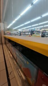 Cutting sticker list kuning pada kaca etalase counter minimarket Ayu Nadi