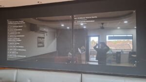 Cutting sticker putih daftar nama perusahaan pada papan akrilik directory kantor