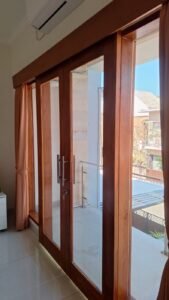 Kaca film pada pintu kaca kusen kayu kamar tidur menghadap balkon