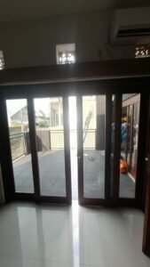 Pemasangan kaca film pada pintu kaca lipat kusen kayu menuju teras rumah