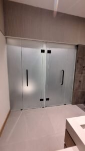 Sticker sandblast pada pintu kaca frameless double di area kamar mandi