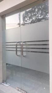 Sticker sandblast dengan list garis pada pintu kaca frameless double