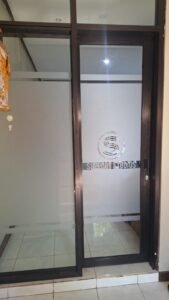 Sticker sandblast dengan logo Support Studios pada pintu kaca geser kantor