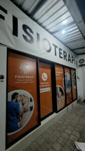 Sticker print branding klinik fisioterapi pada kaca etalase depan