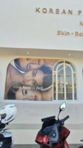 Sticker print visual wajah model From Seoul to Bali pada kaca fasad klinik kecantikan